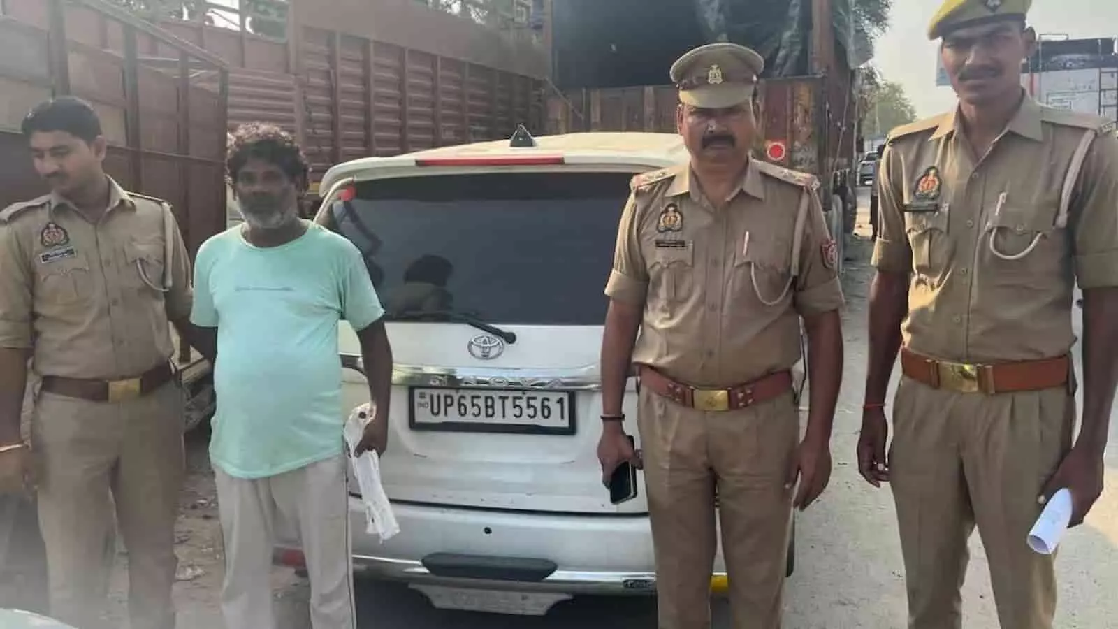 तस्वीर में पुलिसकर्मियों की गिरफ्त में खड़ा आरोपी और पीछे खड़ी गाड़ी दिख रही है। तस्वीर में पुलिसकर्मियों की गिरफ्त में खड़ा आरोपी और पीछे खड़ी गाड़ी दिख रही है।
