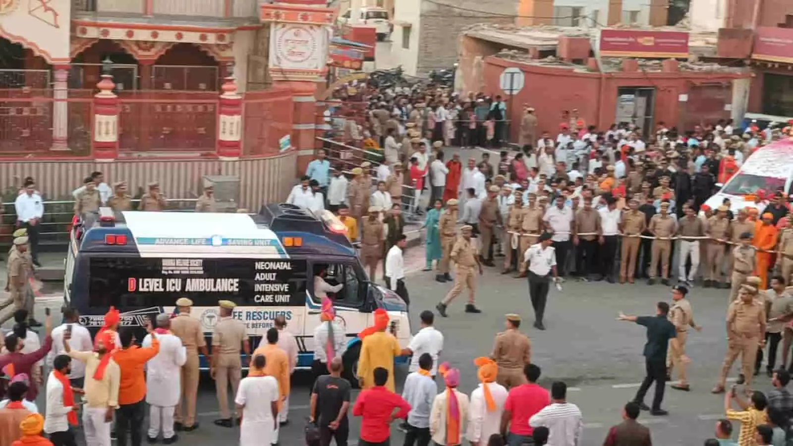 गोरखनाथ मंदिर के सामने भीड़ के बीच से गुजरती एंबुलेंस और रास्ता बनाते सुरक्षाकर्मी गोरखनाथ मंदिर के सामने भीड़ के बीच से गुजरती एंबुलेंस और रास्ता बनाते सुरक्षाकर्मी