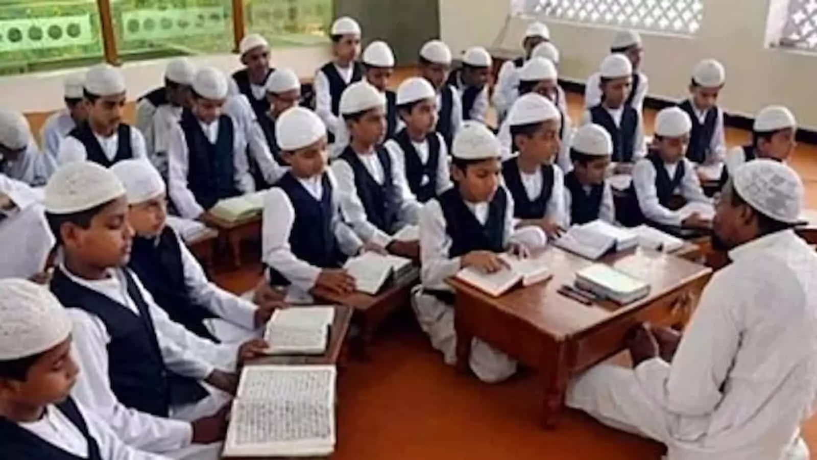 तस्वीर में मदरसा कक्षा के अंदर छात्र पढ़ाई करते हुए दिखाई दे रहे हैं। तस्वीर में मदरसा कक्षा के अंदर छात्र पढ़ाई करते हुए दिखाई दे रहे हैं।