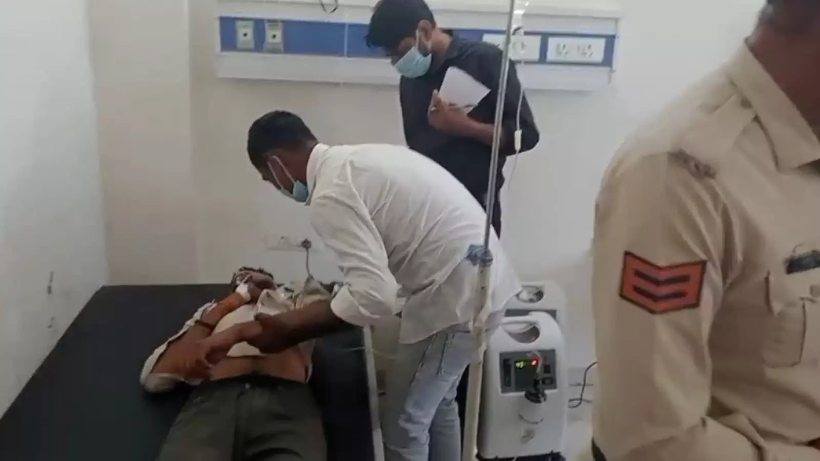 तस्वीर में अस्पताल के बिस्तर पर लेटे घायल युवक को डॉक्टर उपचार देते हुए और पुलिसकर्मी नजर आ रहे हैं। तस्वीर में अस्पताल के बिस्तर पर लेटे घायल युवक को डॉक्टर उपचार देते हुए और पुलिसकर्मी नजर आ रहे हैं।