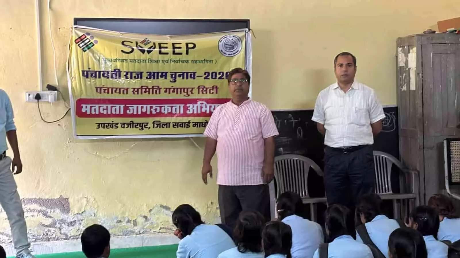 तस्वीर में स्वीप बैनर के सामने अधिकारी राजकीय विद्यालय में छात्रों को मतदाता पंजीकरण की जानकारी देते हुए दिख रहे हैं। तस्वीर में स्वीप बैनर के सामने अधिकारी राजकीय विद्यालय में छात्रों को मतदाता पंजीकरण की जानकारी देते हुए दिख रहे हैं।