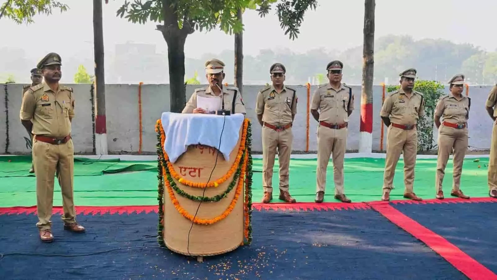 तस्वीर में एटा पुलिस लाइन में पॉडियम पर खड़े होकर संबोधन पढ़ते पुलिस अधिकारी दिख रहे हैं। तस्वीर में एटा पुलिस लाइन में पॉडियम पर खड़े होकर संबोधन पढ़ते पुलिस अधिकारी दिख रहे हैं।