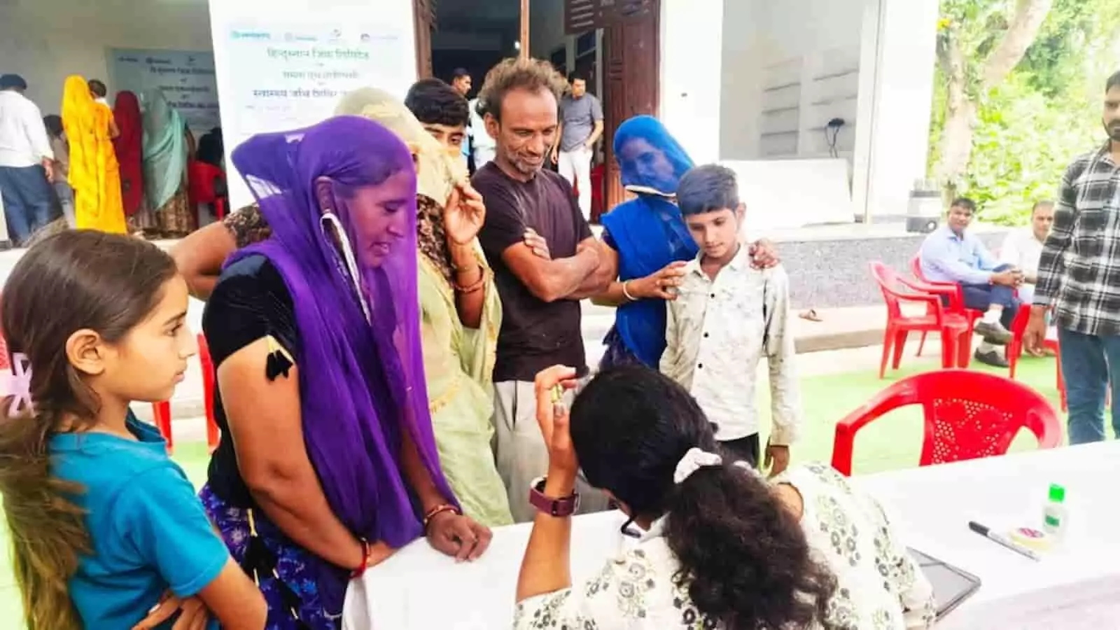 तस्वीर में एक स्वास्थ्य शिविर में डॉक्टर से परामर्श लेते ग्रामीण महिला और पुरुष मरीज। तस्वीर में एक स्वास्थ्य शिविर में डॉक्टर से परामर्श लेते ग्रामीण महिला और पुरुष मरीज।