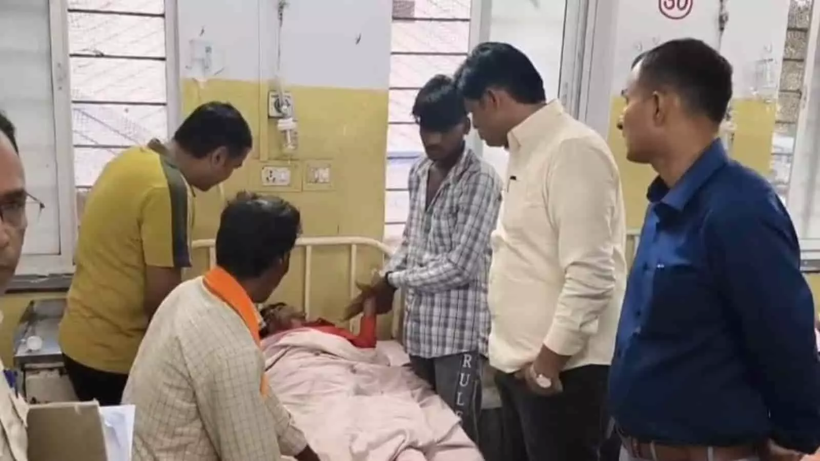 अस्पताल के बेड पर लेटे घायल व्यक्ति की देखभाल करते परिजन और स्वास्थ्यकर्मी। अस्पताल के बेड पर लेटे घायल व्यक्ति की देखभाल करते परिजन और स्वास्थ्यकर्मी।