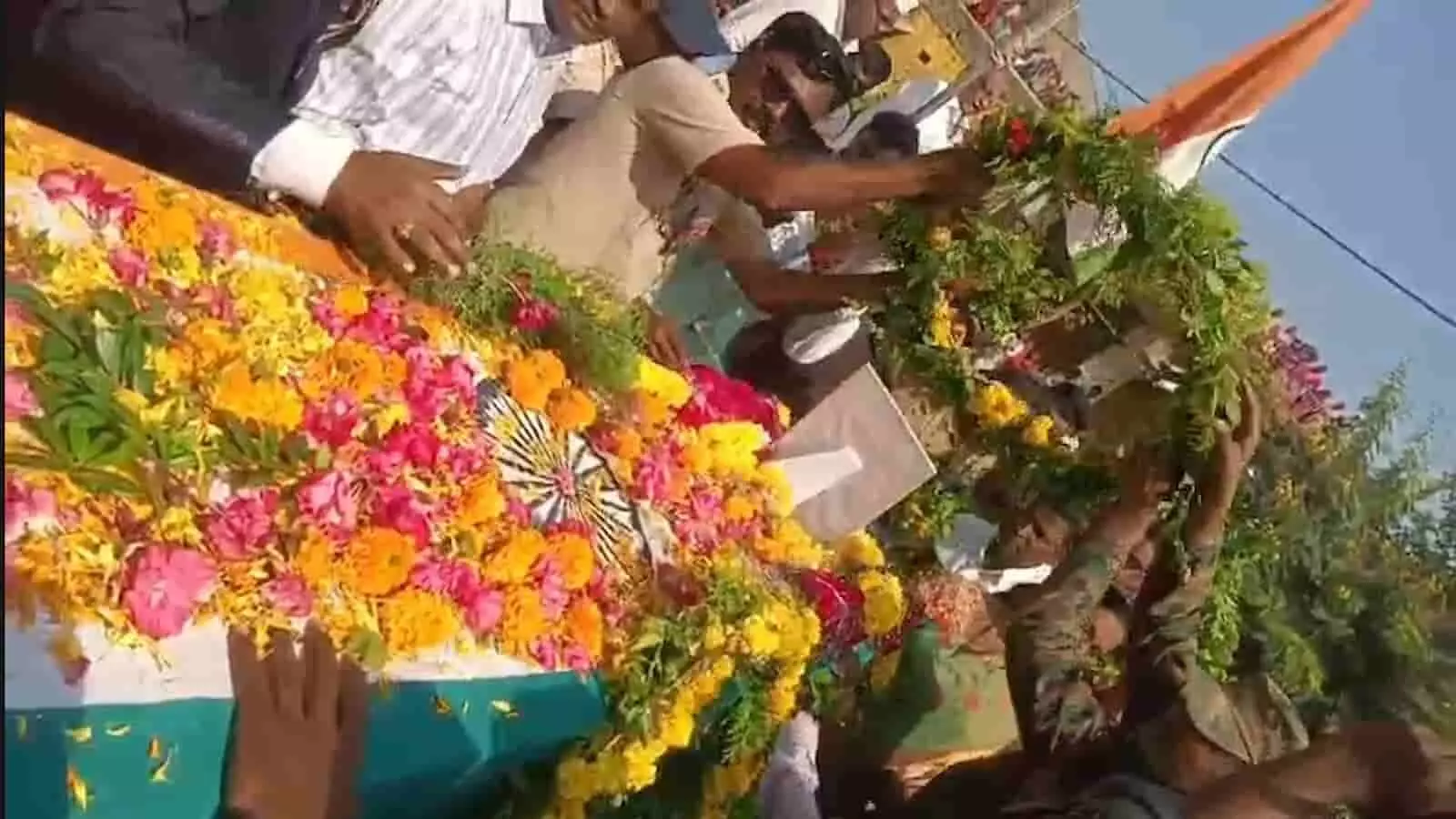 तस्वीर में तिरंगे में लिपटे शहीद समाधान मधाले के पार्थिव शरीर पर लोग फूल अर्पित कर रहे हैं। तस्वीर में तिरंगे में लिपटे शहीद समाधान मधाले के पार्थिव शरीर पर लोग फूल अर्पित कर रहे हैं।