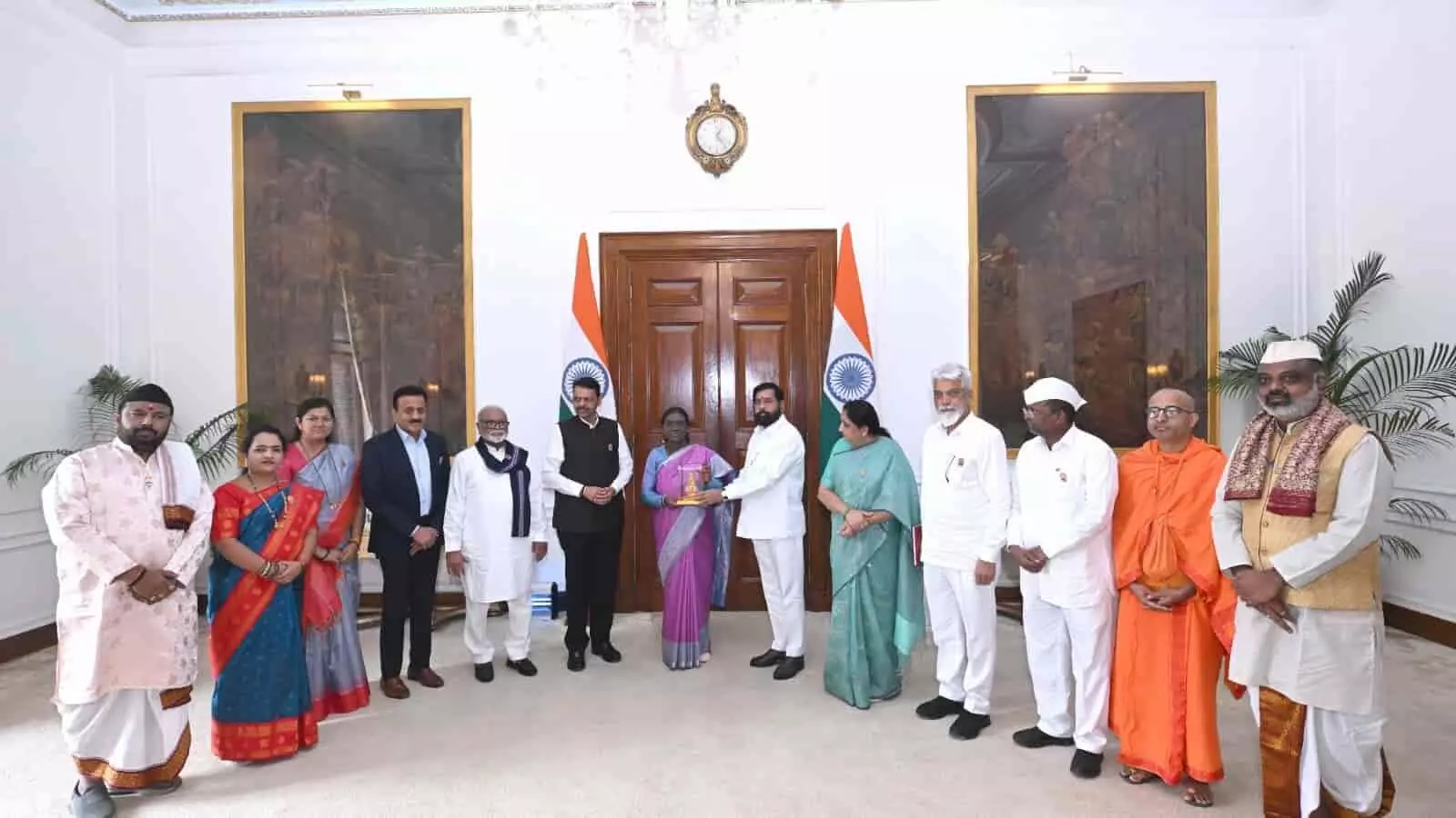 तस्वीर में राष्ट्रपति भवन में द्रौपदी मुर्मू को देवेंद्र फडणवीस और अन्य मंत्री कुंभमेला निमंत्रण पत्र सौंपते दिख रहे हैं। तस्वीर में राष्ट्रपति भवन में द्रौपदी मुर्मू को देवेंद्र फडणवीस और अन्य मंत्री कुंभमेला निमंत्रण पत्र सौंपते दिख रहे हैं।