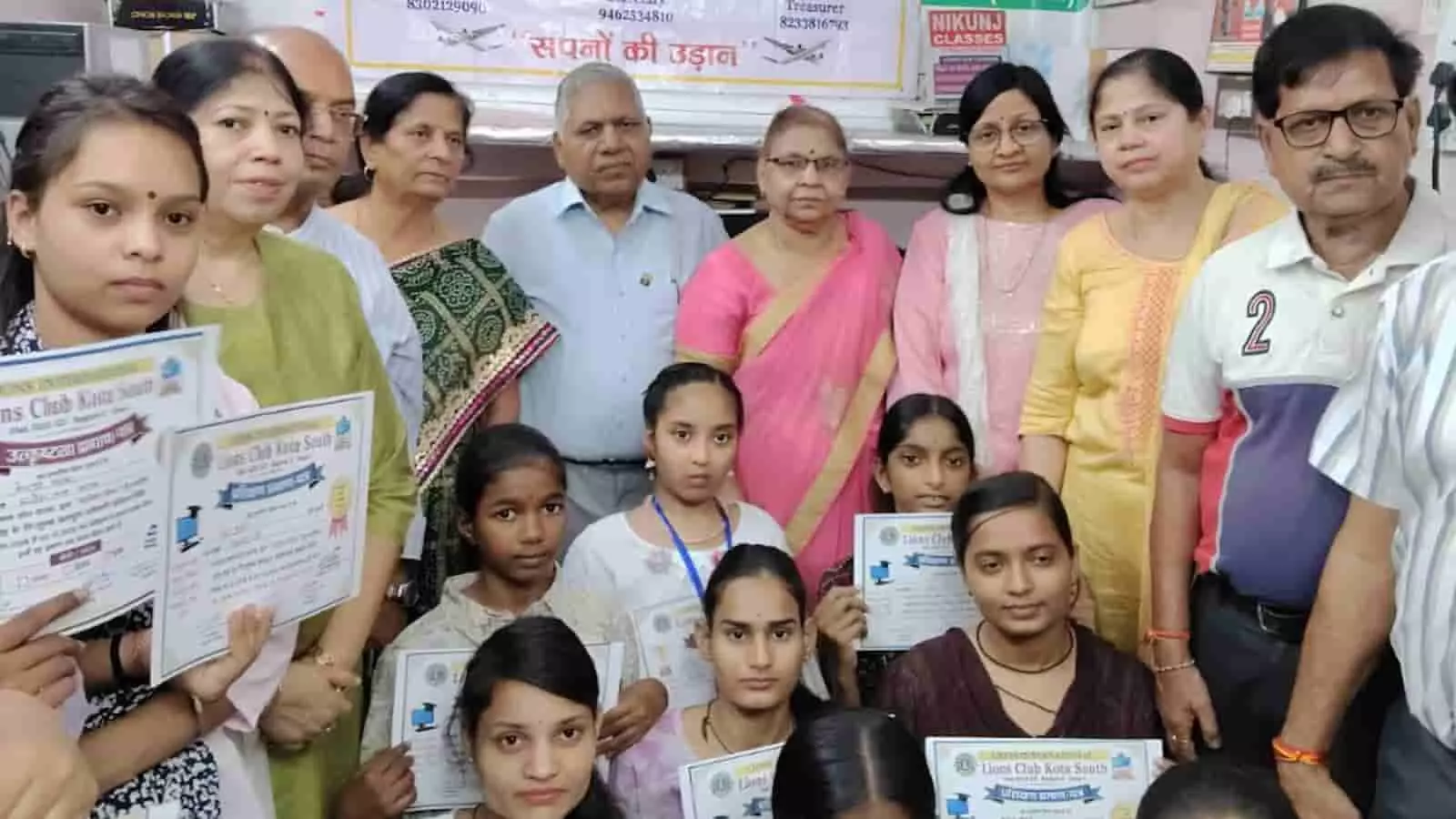 तस्वीर में कोटा में आयोजित कार्यक्रम के दौरान प्रमाण पत्र थामे बच्चे और सदस्य दिखाई दे रहे हैं। तस्वीर में कोटा में आयोजित कार्यक्रम के दौरान प्रमाण पत्र थामे बच्चे और सदस्य दिखाई दे रहे हैं।