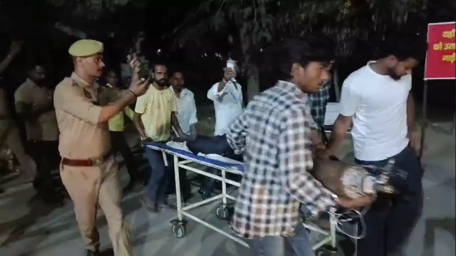 तस्वीर में पुलिसकर्मी और परिजन घायल दुकानदार को कासगंज जिला अस्पताल में ले जाते हुए दिख रहे हैं. तस्वीर में पुलिसकर्मी और परिजन घायल दुकानदार को कासगंज जिला अस्पताल में ले जाते हुए दिख रहे हैं.