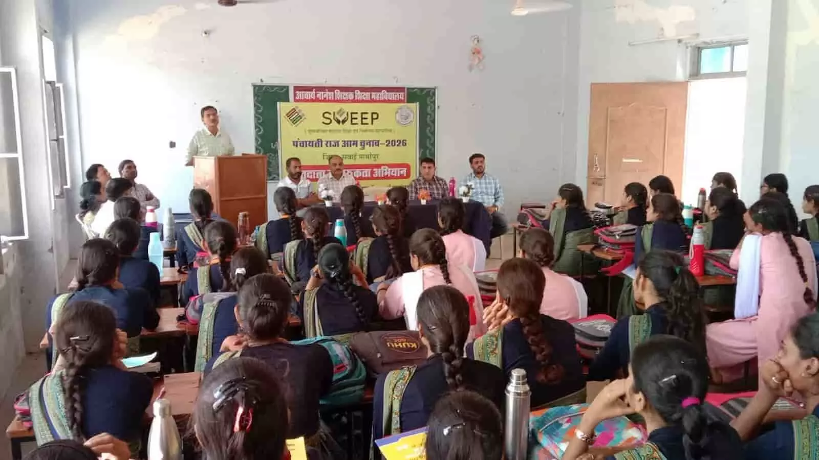 तस्वीर में सवाई माधोपुर के कॉलेज हॉल में मतदाता जागरूकता कार्यक्रम के दौरान उपस्थित छात्राएं और भाषण देते अधिकारी। तस्वीर में सवाई माधोपुर के कॉलेज हॉल में मतदाता जागरूकता कार्यक्रम के दौरान उपस्थित छात्राएं और भाषण देते अधिकारी।