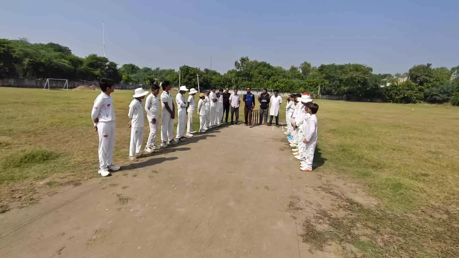 तस्वीर में क्रिकेट मैदान की पिच पर खड़े युवा खिलाड़ी और अधिकारी सवाई माधोपुर मैच के दौरान दिख रहे हैं। तस्वीर में क्रिकेट मैदान की पिच पर खड़े युवा खिलाड़ी और अधिकारी सवाई माधोपुर मैच के दौरान दिख रहे हैं।