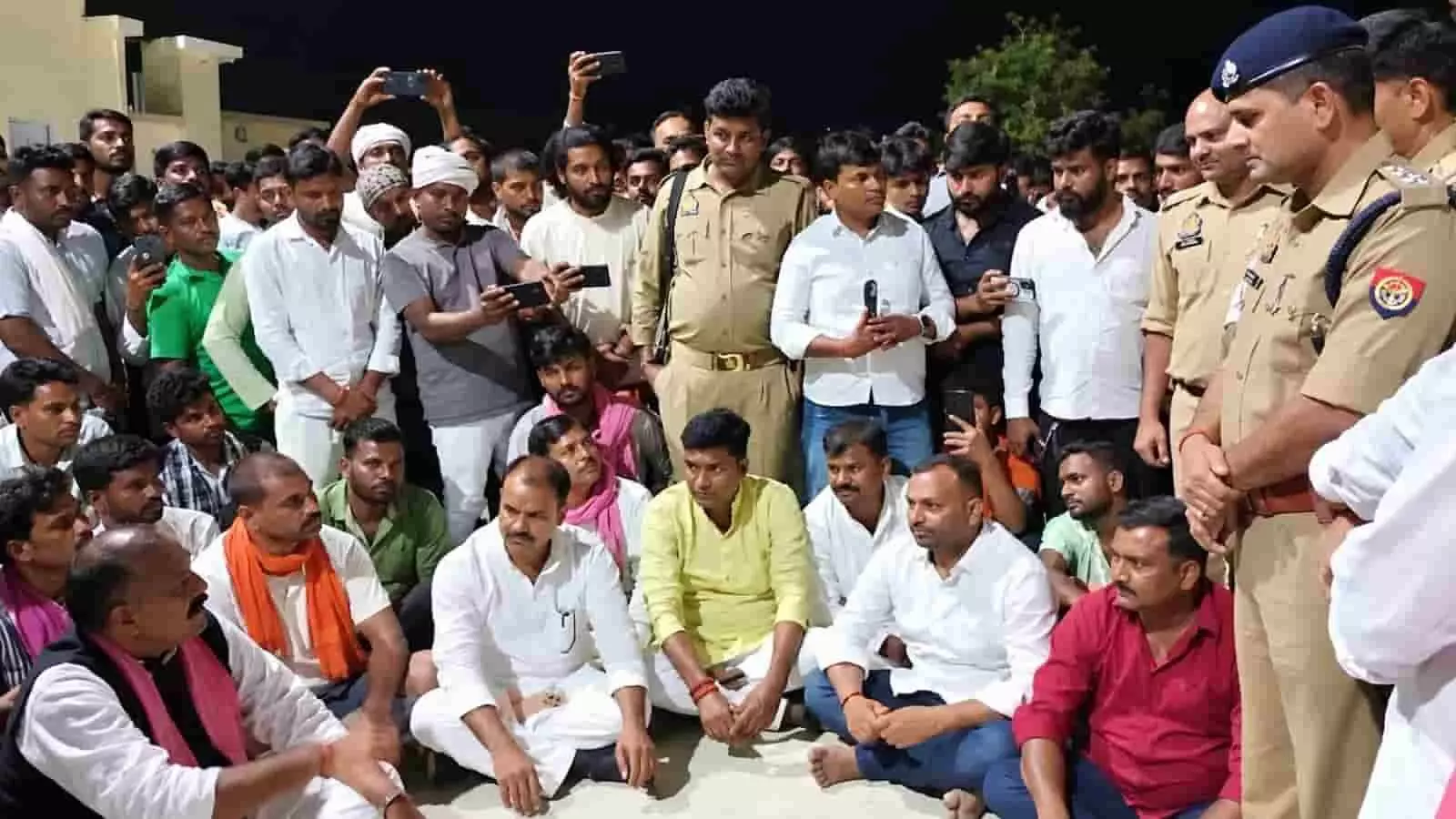 तस्वीर में चंदौली पुलिस लाइन के बाहर जमीन पर बैठे प्रदर्शनकारी ग्रामीण और पुलिस बल दिख रहे हैं। तस्वीर में चंदौली पुलिस लाइन के बाहर जमीन पर बैठे प्रदर्शनकारी ग्रामीण और पुलिस बल दिख रहे हैं।