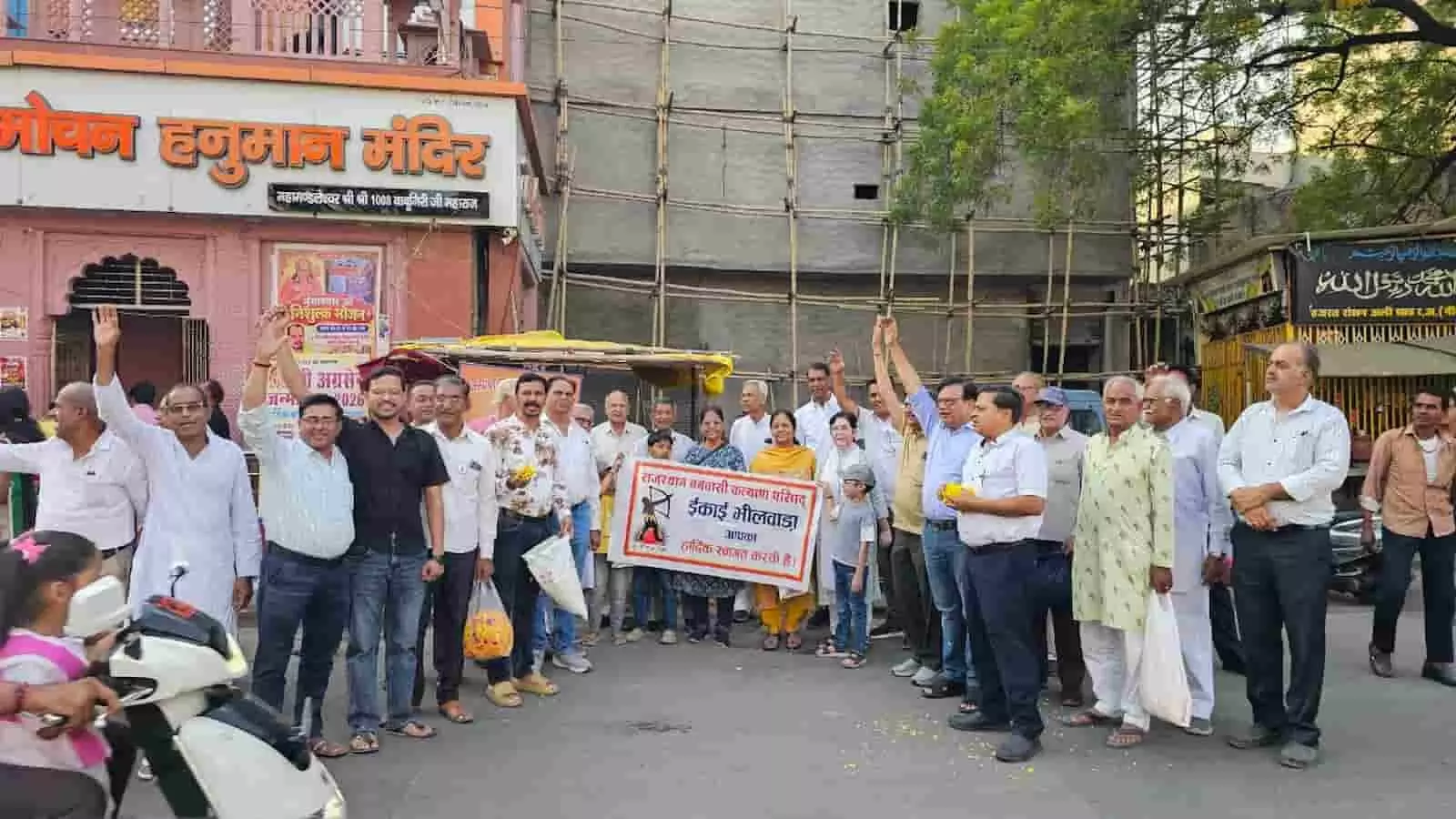 तस्वीर में भीलवाड़ा संकट मोचन हनुमान मंदिर के बाहर बैनर लेकर खड़े वनवासी कल्याण परिषद के पदाधिकारी स्वागत करते हुए दिख रहे हैं। तस्वीर में भीलवाड़ा संकट मोचन हनुमान मंदिर के बाहर बैनर लेकर खड़े वनवासी कल्याण परिषद के पदाधिकारी स्वागत करते हुए दिख रहे हैं।