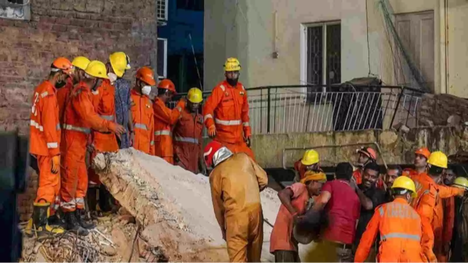 राहत और बचाव कार्य में जुटे एनडीआरएफ कर्मी व स्थानीय लोग दिल्ली के हर्ष विहार में।