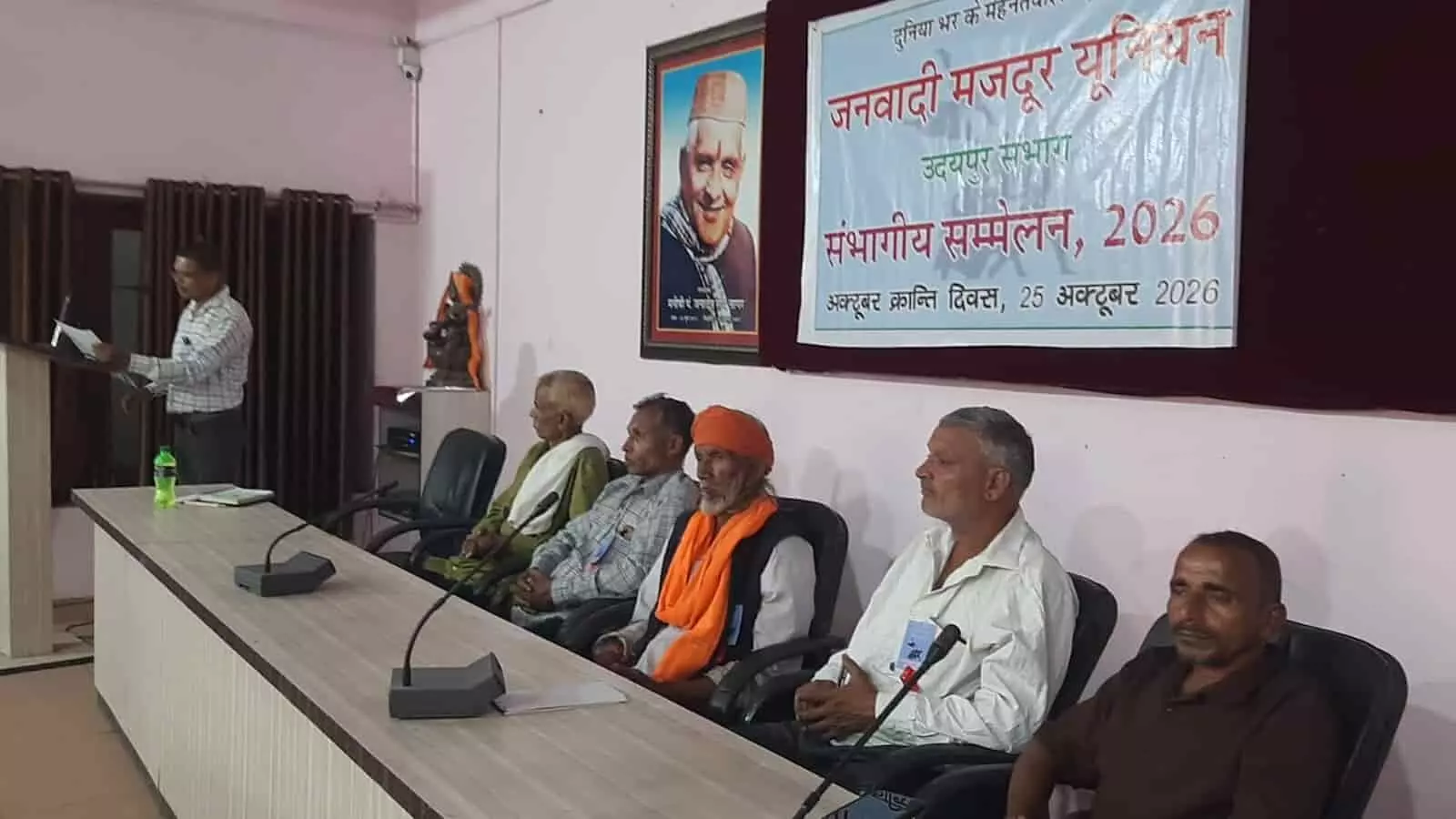 तस्वीर में मंच पर बैठे पदाधिकारी और मंच संचालन करते वक्ता जनवादी मजदूर यूनियन के सम्मेलन में दिख रहे हैं। तस्वीर में मंच पर बैठे पदाधिकारी और मंच संचालन करते वक्ता जनवादी मजदूर यूनियन के सम्मेलन में दिख रहे हैं।