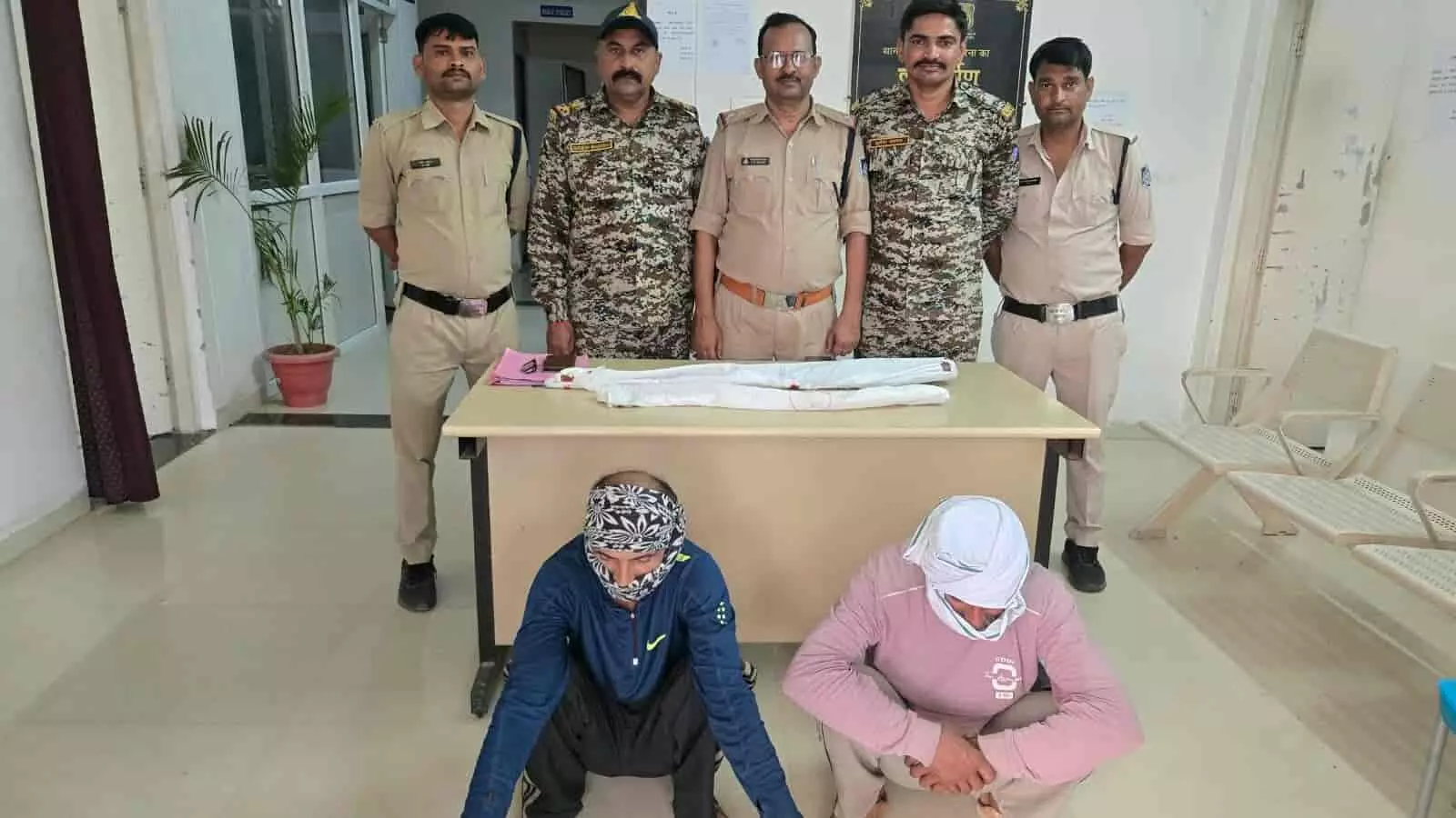 तस्वीर में पुलिसकर्मियों के साथ फर्श पर बैठे दो आरोपी पोरसा थाने में जब्त हथियारों के साथ दिख रहे हैं। तस्वीर में पुलिसकर्मियों के साथ फर्श पर बैठे दो आरोपी पोरसा थाने में जब्त हथियारों के साथ दिख रहे हैं।
