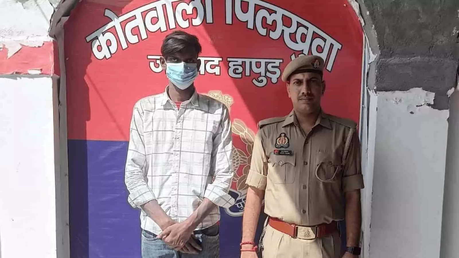 तस्वीर में पिलखुवा कोतवाली के बाहर पुलिसकर्मी के साथ गिरफ्तार किया गया आरोपी नजर आ रहा है। तस्वीर में पिलखुवा कोतवाली के बाहर पुलिसकर्मी के साथ गिरफ्तार किया गया आरोपी नजर आ रहा है।