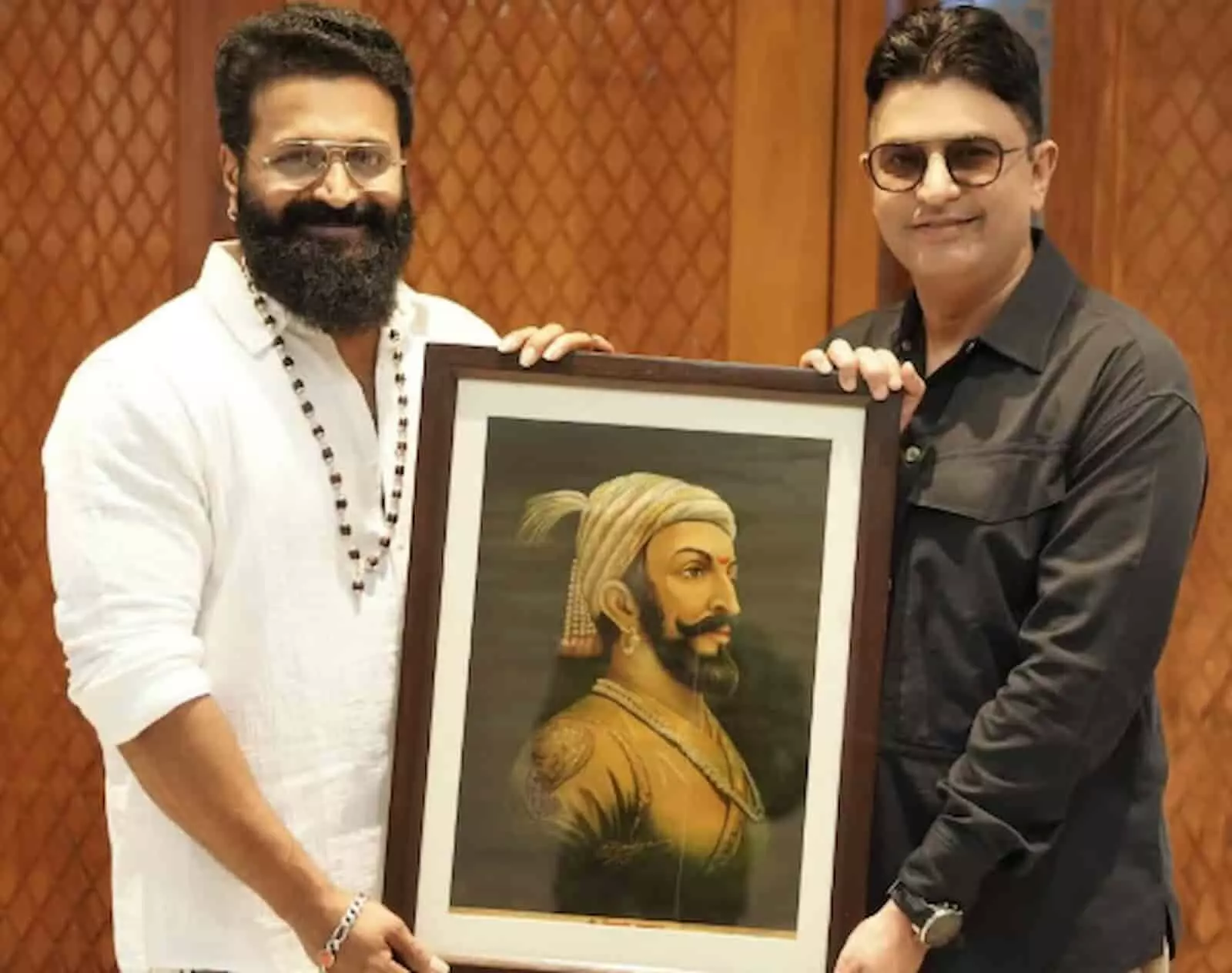 तस्वीर में ऋषभ शेट्टी और भूषण कुमार छत्रपति शिवाजी महाराज की पेंटिंग पकड़े हुए खड़े हैं।