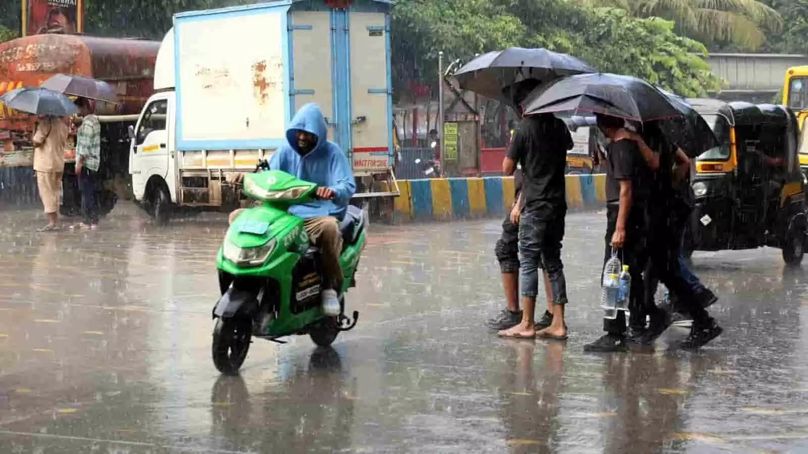 मुंबई की सड़क पर बारिश में छतरी लिए पैदल यात्री और स्कूटर सवार व्यक्ति नजर आ रहे हैं। मुंबई की सड़क पर बारिश में छतरी लिए पैदल यात्री और स्कूटर सवार व्यक्ति नजर आ रहे हैं।