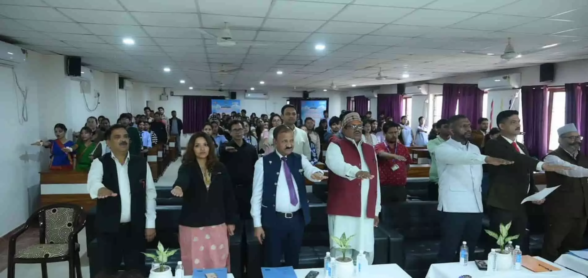 तस्वीर में हॉल के भीतर एक हाथ आगे बढ़ाकर शपथ लेते हुए अतिथि और युवा प्रतिभागी। तस्वीर में हॉल के भीतर एक हाथ आगे बढ़ाकर शपथ लेते हुए अतिथि और युवा प्रतिभागी।