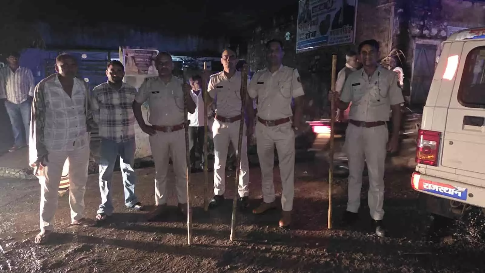 तस्वीर में रात के समय राजस्थान में सुरक्षा व्यवस्था का जायजा लेते हुए पुलिसकर्मी और स्थानीय लोग नजर आ रहे हैं। तस्वीर में रात के समय राजस्थान में सुरक्षा व्यवस्था का जायजा लेते हुए पुलिसकर्मी और स्थानीय लोग नजर आ रहे हैं।